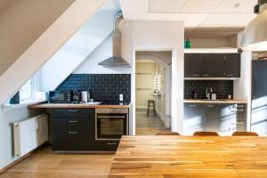 a kitchen with black cabinets and a wooden floor at Kings Garden 2 by Daniel&Jacob's in Copenhagen +53 photos