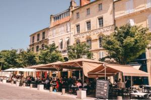 a group of tables and umbrellas in front of a building at Domaine à Marmande in Berdoues