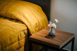 a vase of flowers on a table next to a bed at Cosmo Napa Boutique Hotel in Ayia Napa