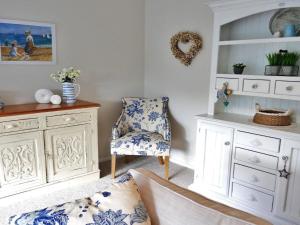 a bedroom with a bed and a chair and a cabinet at Sealark in Callala Bay