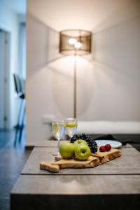 a table with two wine glasses and fruit on a cutting board at Cosmo Napa Boutique Hotel in Ayia Napa