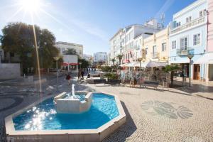 una fuente en medio de una calle con edificios en Casinha Canal - Beautifully restored Moroccan inspired townhouse in Lagos historic centre, en Lagos