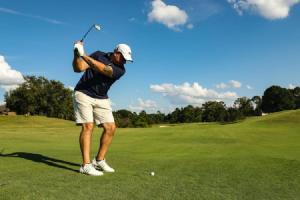 a man swinging a golf club on a golf course at Domaine à Marmande in Berdoues