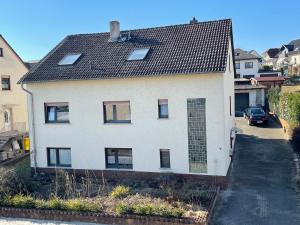 Biały dom z czarnym dachem w obiekcie Monteurwohnung - FerienWohnung nähe Limburg an der Lahn w mieście Flacht