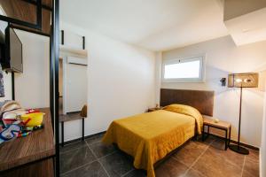 a bedroom with a bed with a yellow blanket at Cosmo Napa Boutique Hotel in Ayia Napa