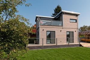 a house with a large deck on a lawn at Ferienhaus Segelhafen8 in Südbrookmerland