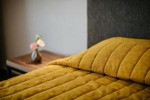 a close up of a yellow bed with a vase of flowers at Cosmo Napa Boutique Hotel in Ayia Napa