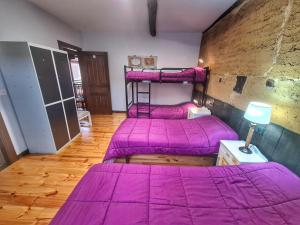 two bunk beds in a room with pink sheets at Albergue El Encanto in Villares de Órbigo
