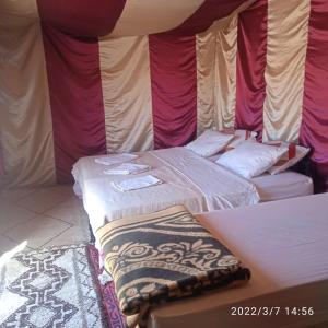 a room with two beds in a tent at Chegaga Berber Camps in Mhamid