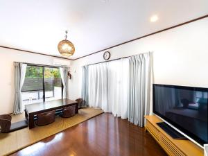 a living room with a large television and a table at Sea Stay Okinawa in Onna