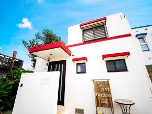 a white building with a sign in front of it at Sea Stay Okinawa in Onna