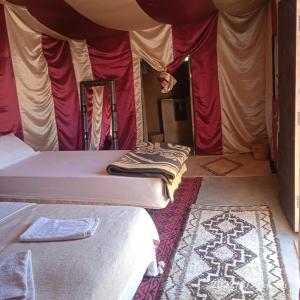 a room with two beds in a tent at Chegaga Berber Camps in Mhamid