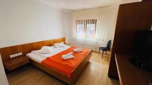 a bedroom with a bed with two towels on it at Pensiunea Luminita in Buşteni