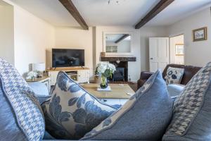 uma sala de estar com um sofá e uma mesa em Ropemaker’s Cottage em Ollerton