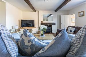 a living room with a couch and a table at Ropemaker’s Cottage in Ollerton