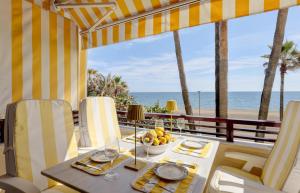 einen Esstisch mit Blick auf den Strand in der Unterkunft Apartment - Car included in Estepona