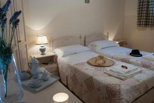 a bedroom with two beds with a hat on a table at Agriturismo Al Casale in Donnafugata