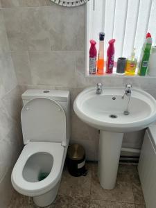 a bathroom with a toilet and a sink at Milnrow Road - Spacious 3 bed house 