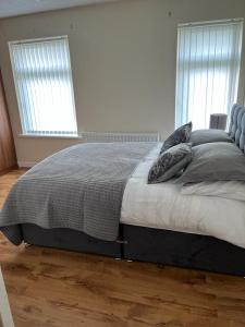 a bed in a bedroom with two pillows on it at Milnrow Road - Spacious 3 bed house 