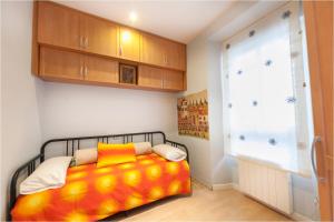 a bedroom with a bed with an orange blanket at TERANGA: Piso en Plaza Mayor de Valladolid in Valladolid