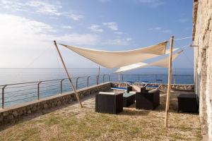 a tent and chairs on the beach near the water at Residence La Punta in Marina di Camerota