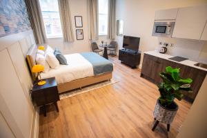 ein großes Schlafzimmer mit einem Bett und einer Küche in der Unterkunft The Gresham Aparthotel in Leicester