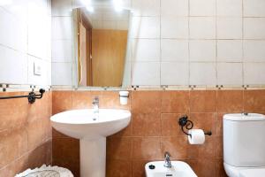 łazienka z umywalką, toaletą i lustrem w obiekcie Apartamento Sol - Sólo Familias w mieście Conil de la Frontera +13 zdjęć