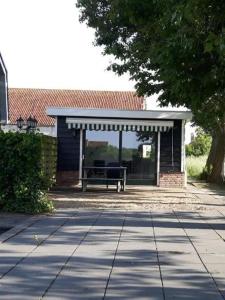 a picnic shelter with a bench in a yard at Vakantiewoning de Schelp in Ellemeet