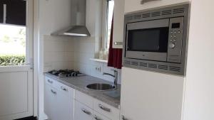 a kitchen with a sink and a microwave at Vakantiewoning de Schelp in Ellemeet