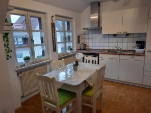 uma cozinha com uma mesa e cadeiras numa cozinha em Ferienwohnung -Main- Ruheplatz am Wasser 