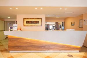 a lobby with a white and wooden counter top at Forte Hotel in Vieste