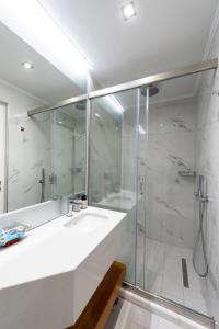 a white bathroom with a sink and a shower at Dias Luxury Homes in Koskinou