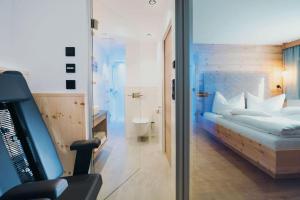 a hotel room with a bed and a television at das Luggi Appartements in Reith im Alpbachtal