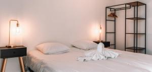 a bedroom with a white bed with two lamps at Appartement Godderis I, 9de verdieping in Blankenberge