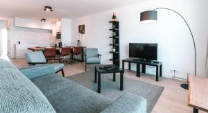 a living room with a couch and a tv and a table at Appartement Godderis I, 9de verdieping in Blankenberge