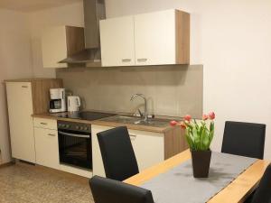 a kitchen with a table with a vase of flowers on it at Ferienwohnung Leo in Bad Endorf