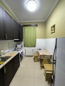 a kitchen with black cabinets and a green curtain at Freedom Square Apartment in Tbilisi City