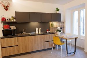 トレントにあるMUROS - Design Apartments in Trentoのキッチン(テーブル、電子レンジ付)