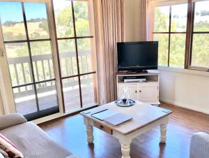 a living room with a tv and a coffee table at Balingup Highview Chalets in Balingup