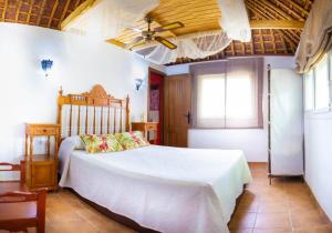 a bedroom with a bed and a ceiling fan at Finca el Abuelo Manuel in Vejer de la Frontera +26 photos