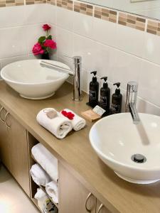 a bathroom with a sink and a mirror and towels at Balingup Highview Chalets in Balingup