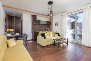 a living room with a yellow couch and a table at Apartamenty Bałtycka by Renters in Świnoujście