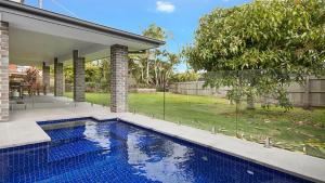 a swimming pool in the backyard of a house at The Palms - Lennox Head in Lennox Head