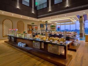 a buffet line in a restaurant with food on display at Essentia Luxury Hotel Indore in Indore