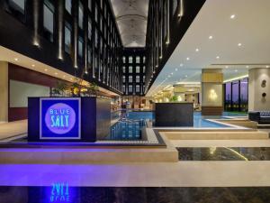 a lobby with a blue salt sign in a building at Essentia Luxury Hotel Indore in Indore