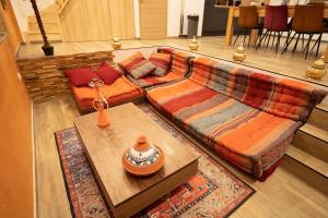 een woonkamer met een bank en een tafel bij Capsule Marrakech I Chicha I Sauna I Balnéo I Console PS5 I Cinéma in Trith-Saint-Léger