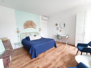 sypialnia z niebieskim łóżkiem i biurkiem w obiekcie Chambres d'hotes - Le Magnolia w Carcassonne