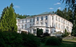 um grande edifício branco com um cartaz em Parkhotel Golf Marianske Lazne em Mariánské Lázně