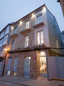 a building with windows and balconies on a street at Apartamentos Turísticos As Burgas 6 by Bossh Hotels in Ourense
