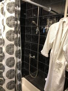 a bathroom with a shower with a black and white shower curtain at Curcanilor 18 in Braşov